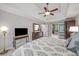 Bright main bedroom with tray ceiling, dark furniture and open access to the bath at 2425 Hamptons Psge, Alpharetta, GA 30005