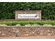Community sign for 'The Hamptons' set against a stone wall and manicured greenery at 2425 Hamptons Psge, Alpharetta, GA 30005