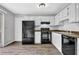 Well-lit kitchen with black appliances, white cabinets, and updated flooring at 2584 Shadowbrook Dr, Decatur, GA 30034
