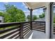 View from the balcony with dark wood railing overlooking the street and lush green trees at 515 Cohen St, Atlanta, GA 30310