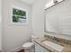 Bathroom features a window, toilet, large mirror, and granite countertop on vanity at 515 Cohen St, Atlanta, GA 30310