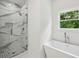 Bright bathroom with glass walk-in shower with rainfall showerhead and a modern soaking tub at 515 Cohen St, Atlanta, GA 30310