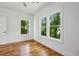 Bedroom features hardwood floors, white walls, and two large windows overlooking green trees at 515 Cohen St, Atlanta, GA 30310
