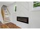 Hallway features a modern electric fireplace with staircase and hardwood floors at 515 Cohen St, Atlanta, GA 30310