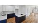 Modern kitchen features white and navy cabinets, quartz counters, stainless steel faucet, and hardwood floors at 515 Cohen St, Atlanta, GA 30310