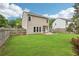 Expansive backyard featuring a lush lawn, a patio area with outdoor seating, and a wooden fence for privacy at 5225 Stonehaven Vw, Cumming, GA 30040