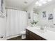 Well-lit bathroom with a dark wood vanity, white countertop, and shower with a white curtain at 5225 Stonehaven Vw, Cumming, GA 30040
