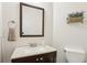 Half bathroom featuring a modern vanity with granite countertop and decorative mirror at 5225 Stonehaven Vw, Cumming, GA 30040