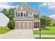 Beautiful home with a manicured lawn, a stone façade, attached garage, and a covered front porch at 5225 Stonehaven Vw, Cumming, GA 30040