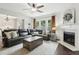 Cozy living room with fireplace, comfortable seating, natural light, and hardwood flooring at 5225 Stonehaven Vw, Cumming, GA 30040