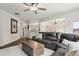 Spacious living area features a large leather sofa, white rug, and easy access to dining area at 5225 Stonehaven Vw, Cumming, GA 30040