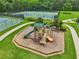 Community playground area with slides and climbing structures, surrounded by lush greenery and walking paths at 5225 Stonehaven Vw, Cumming, GA 30040