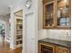 Butler's pantry with glass front cabinets, granite counters, and access to open shelving at 604 Timm Valley Ne Rd # A, Atlanta, GA 30305