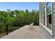 Relaxing balcony area with a chair, wooden deck, and views of the surrounding trees and sky at 1393 Kings Park Nw Dr, Kennesaw, GA 30152