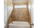 Neutral bathroom featuring a shower-tub combo with decorative tile surround and transom window at 1393 Kings Park Nw Dr, Kennesaw, GA 30152