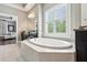 A large soaking tub sits under a sunny window in this primary bathroom at 1393 Kings Park Nw Dr, Kennesaw, GA 30152