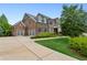 Spacious brick home featuring a three-car garage and meticulously maintained landscaping at 1393 Kings Park Nw Dr, Kennesaw, GA 30152