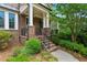 Charming front porch with brick steps, iron railing, and lush landscaping at 1393 Kings Park Nw Dr, Kennesaw, GA 30152