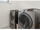 Convenient laundry room featuring modern washer and dryer units and patterned tile floors at 1393 Kings Park Nw Dr, Kennesaw, GA 30152
