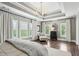 This large main bedroom is illuminated by a modern chandelier and features multiple windows at 1393 Kings Park Nw Dr, Kennesaw, GA 30152