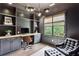 Home office boasts dark grey walls, custom built-ins, stylish light fixture and a comfortable chair and ottoman at 1393 Kings Park Nw Dr, Kennesaw, GA 30152