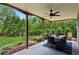 Covered outdoor patio with dining set and ceiling fan, offering a relaxing space surrounded by lush greenery at 1393 Kings Park Nw Dr, Kennesaw, GA 30152
