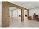 Open playroom featuring exposed brick, light wood floors, and view to living room at 1393 Kings Park Nw Dr, Kennesaw, GA 30152