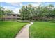 Brick apartment building featuring lush green lawns, mature trees, and a curving walkway at 1800 Clairmont Lk # 213, Decatur, GA 30033