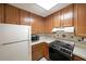 Kitchen with oak cabinets, white appliances, laminate counters, and tile backsplash at 1800 Clairmont Lk # 213, Decatur, GA 30033