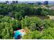 Scenic aerial view showcasing a tranquil lake and pool nestled among green trees with city buildings on the horizon at 24 Dunwoody Springs Dr, Atlanta, GA 30328