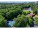 Expansive aerial view showcasing a lush community with a pond, tennis courts, and clubhouse nestled among green trees at 24 Dunwoody Springs Dr, Atlanta, GA 30328