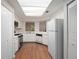 Bright kitchen featuring white cabinetry, black appliances, wood flooring, and a skylight at 24 Dunwoody Springs Dr, Atlanta, GA 30328