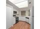 Bright kitchen featuring white cabinetry, black appliances, wood flooring, and a skylight at 24 Dunwoody Springs Dr, Atlanta, GA 30328