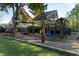 A spacious backyard featuring a wooden playset, lush green grass, and a deck on the house at 680 Parkside Trl, Marietta, GA 30064