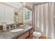 Well-lit bathroom featuring a granite countertop vanity and a shower with a neutral-colored curtain at 680 Parkside Trl, Marietta, GA 30064