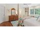 Charming bedroom with a four-poster bed, a dresser with mirror, and a window bench, plus hardwood floors at 680 Parkside Trl, Marietta, GA 30064