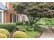Well-manicured landscaping with mature tree leading to a classic brick home with blue front door at 680 Parkside Trl, Marietta, GA 30064