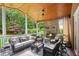 Inviting screened patio featuring comfortable seating, a ceiling fan, and a cozy stone fireplace at 680 Parkside Trl, Marietta, GA 30064