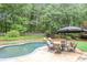 Relaxing backyard pool area complete with lounge chairs, an umbrella, and a lush green surrounding at 680 Parkside Trl, Marietta, GA 30064
