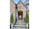 Stone steps lead to a wood front door framed by lush potted evergreens at 1031 Eulalia Ne Rd, Atlanta, GA 30319