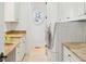 Bright laundry room featuring built-in cabinets, stone countertops, and a porthole window for natural light at 1031 Eulalia Ne Rd, Atlanta, GA 30319