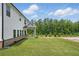 Spacious backyard with lush green grass, trees, and covered patio area for entertaining at 4477 Bethany Manor Dr, Snellville, GA 30039