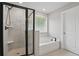 Bathroom featuring a tiled shower, tub with black hardware, and neutral finishes at 4477 Bethany Manor Dr, Snellville, GA 30039