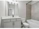 Modern bathroom with tiled shower and tub combo, white toilet, quartz countertop, and painted vanity at 4477 Bethany Manor Dr, Snellville, GA 30039