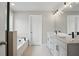 Bright bathroom boasts dual sinks, granite countertop, and a bathtub with tile surround at 4477 Bethany Manor Dr, Snellville, GA 30039