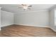 Neutral bedroom showcasing wood-look flooring, a ceiling fan, white trim, and natural light at 4477 Bethany Manor Dr, Snellville, GA 30039