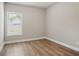 This empty bedroom has natural light, wood floors, and neutral paint at 4477 Bethany Manor Dr, Snellville, GA 30039