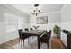 Stylish dining room with hardwood floors, wainscoting, a modern chandelier, and a large window for natural light at 4477 Bethany Manor Dr, Snellville, GA 30039