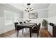 Formal dining room with wainscoting, modern chandelier, and a stylish table setting at 4477 Bethany Manor Dr, Snellville, GA 30039