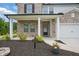 Inviting front entrance with a covered porch, featuring a brick facade, white columns, and landscaped flower beds at 4477 Bethany Manor Dr, Snellville, GA 30039